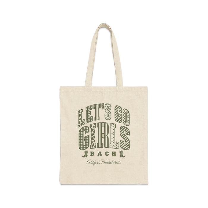 Beige canvas tote bag featuring green text that reads Lets Go Girls Bach Abbys Bachelorette.