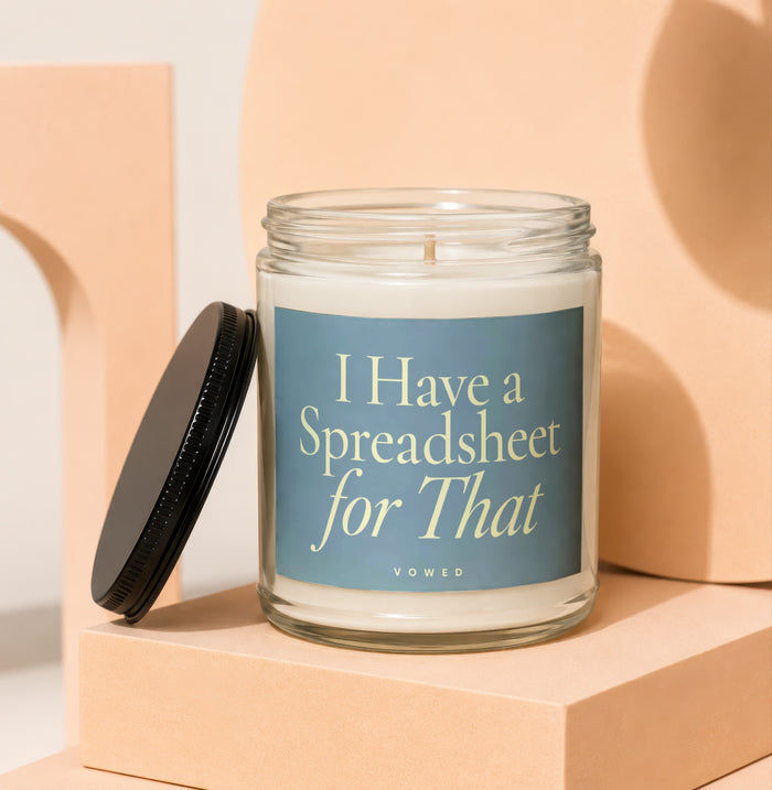 Glass candle with blue label reading "I Have a Spreadsheet for That".