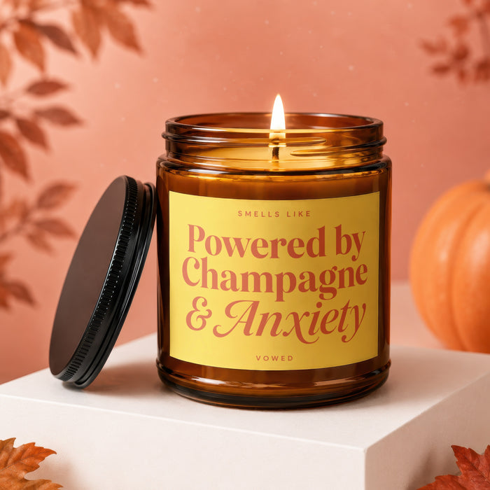Amber candle with lit flame, "Powered by Champagne & Anxiety" text.