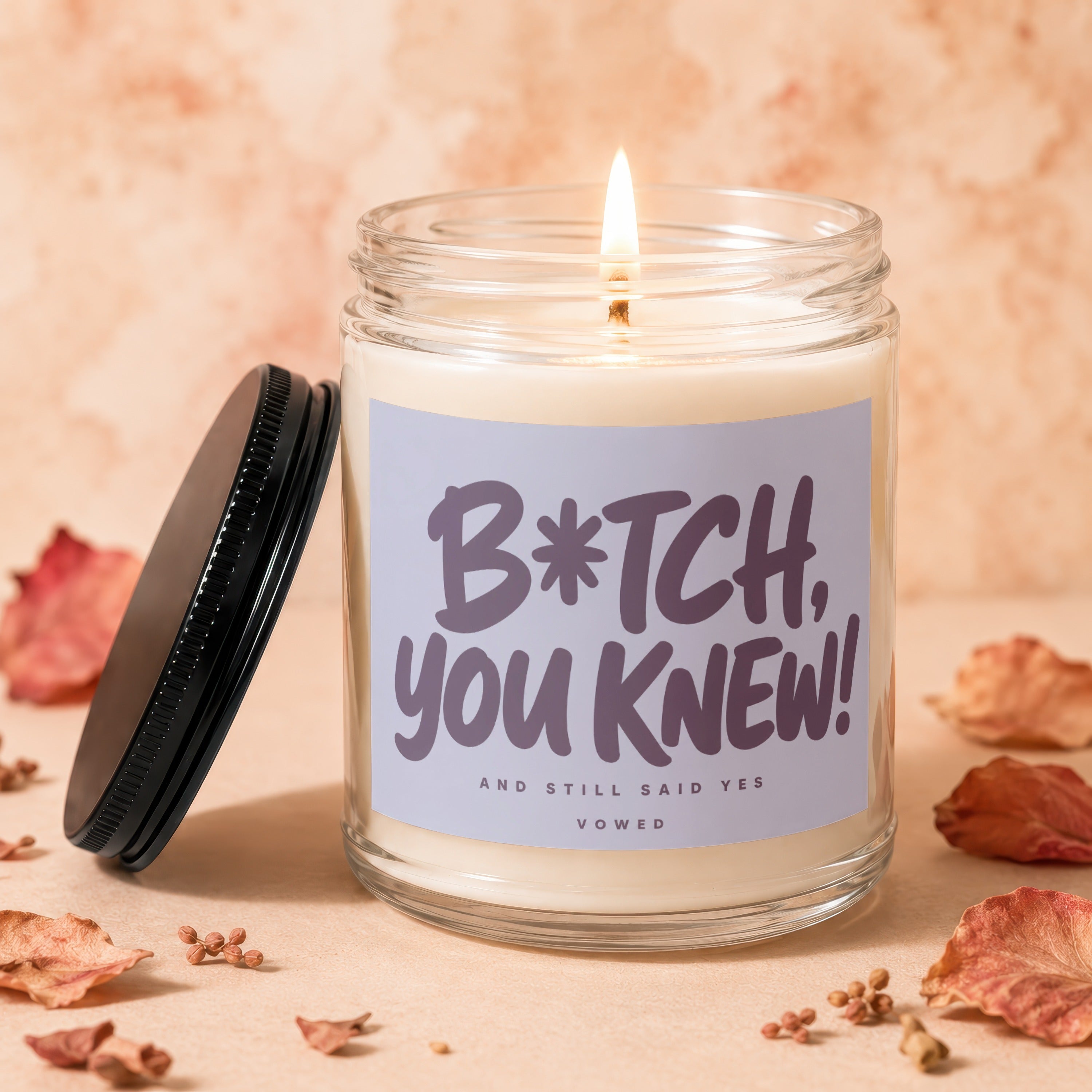 Candle with a lit wick and a label that reads "B*tch, you knew! And still said yes."