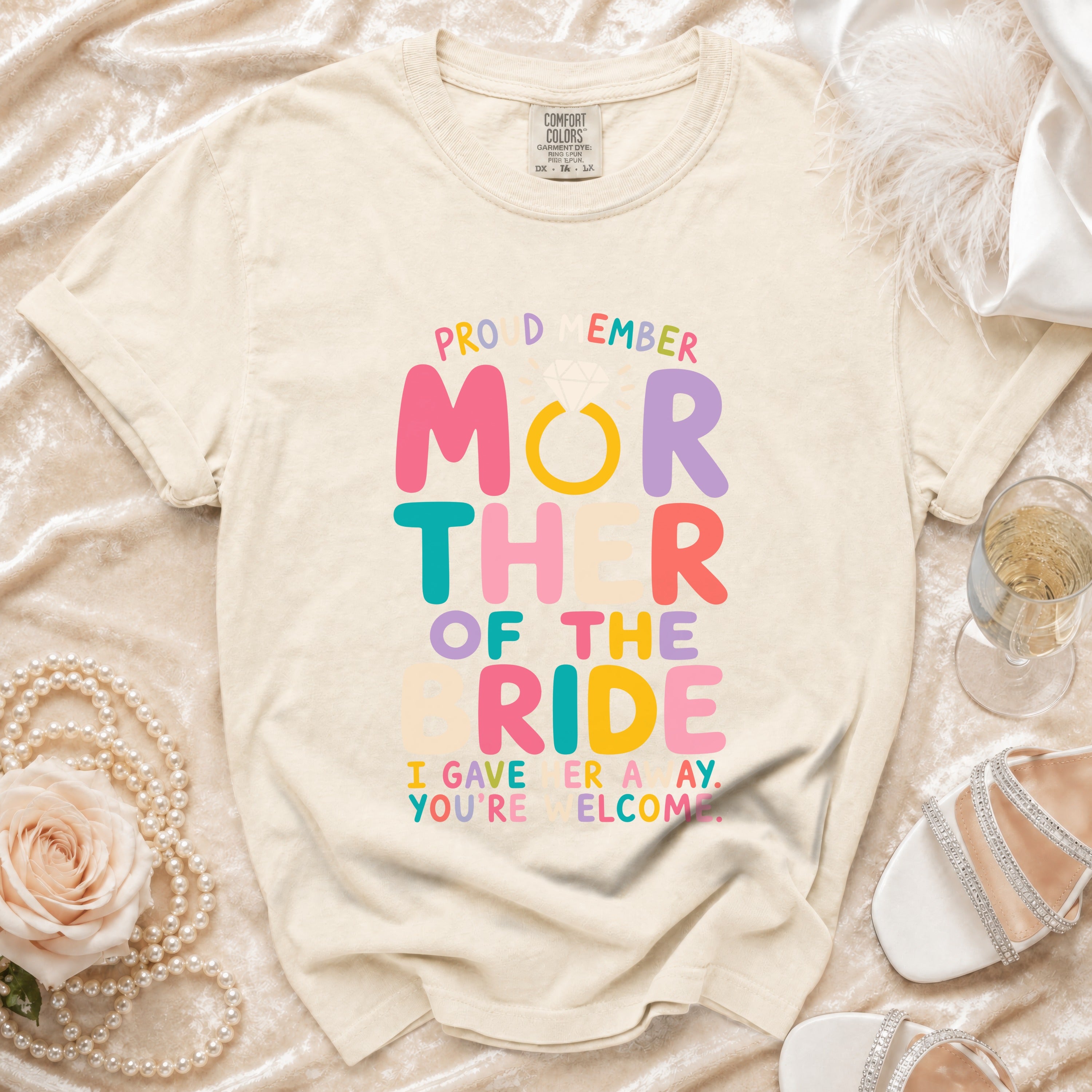 Cream t-shirt with "Proud Mother of the Bride" text and wedding ring graphic.