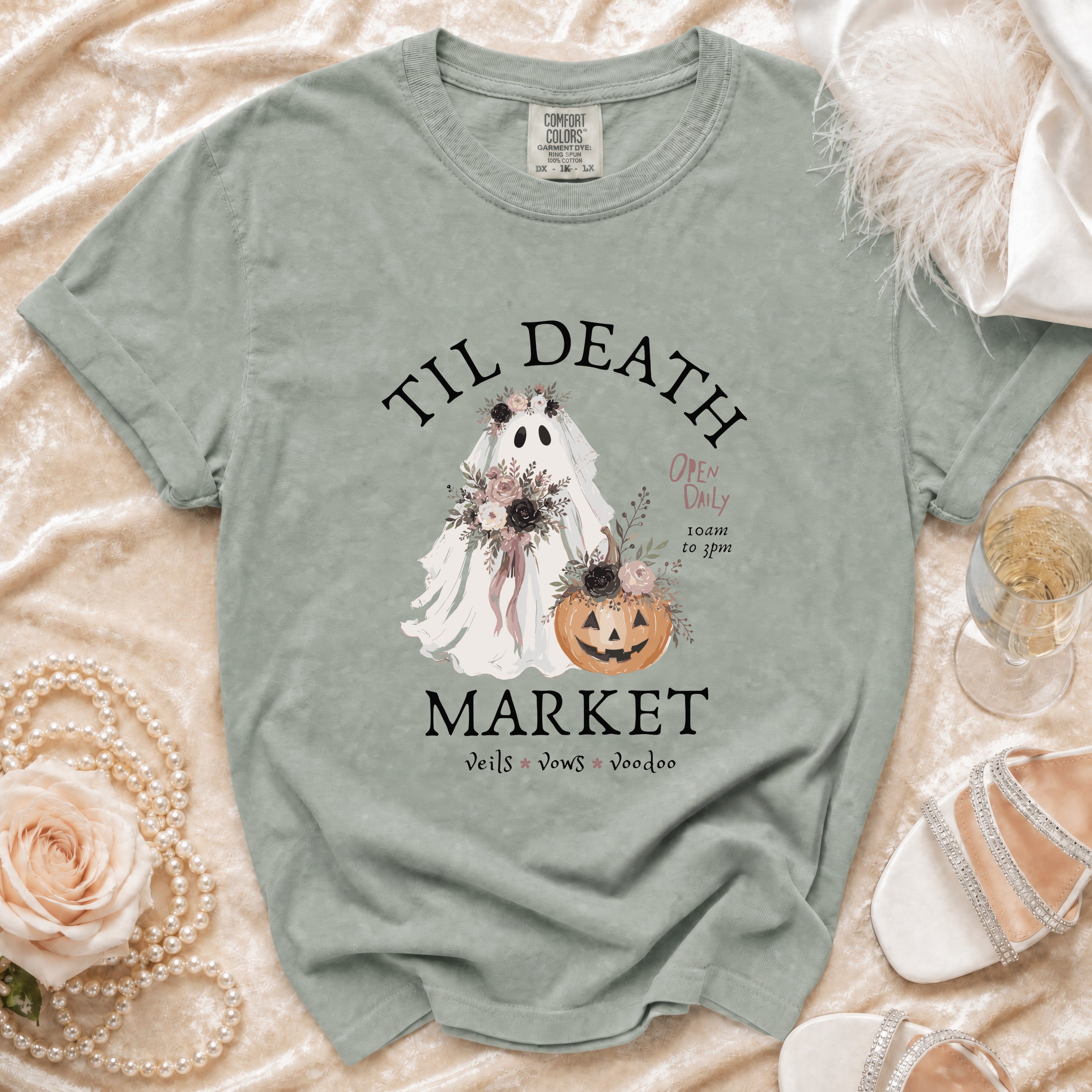 Green t-shirt with "Til Death Market" ghost, pumpkin, and floral graphic.