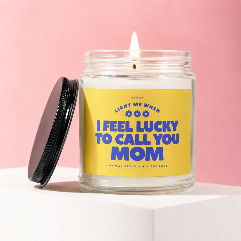 Candle with text "Light me when I feel lucky to call you Mom" on yellow label.