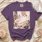 Purple t-shirt featuring a graphic of a ghost in a bathtub with pumpkins and candles.