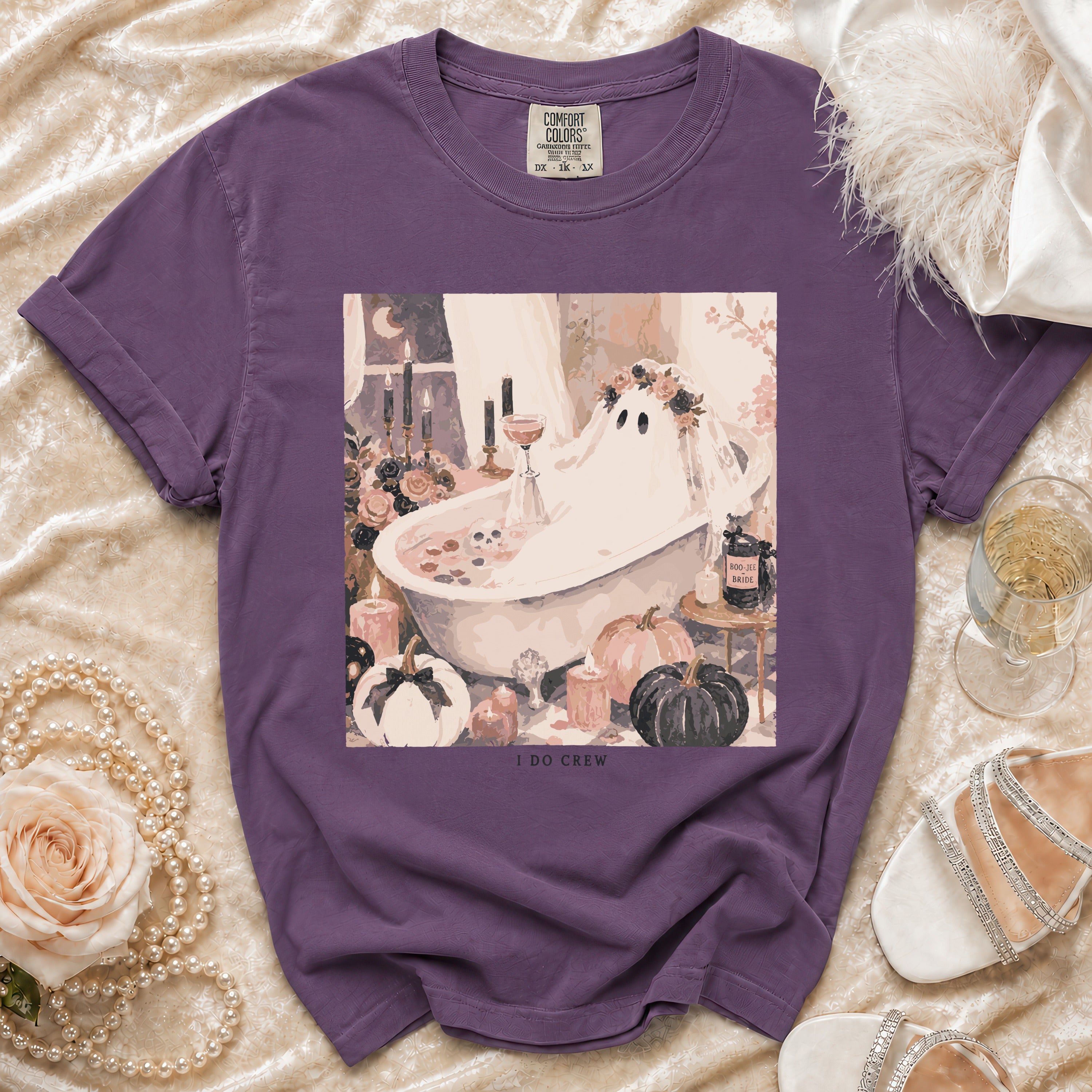Purple t-shirt featuring a graphic of a ghost in a bathtub with pumpkins and candles.