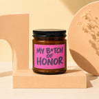 Brown glass candle with pink label reading "MY B*TCH OF HONOR", from Vowed Candle Co.