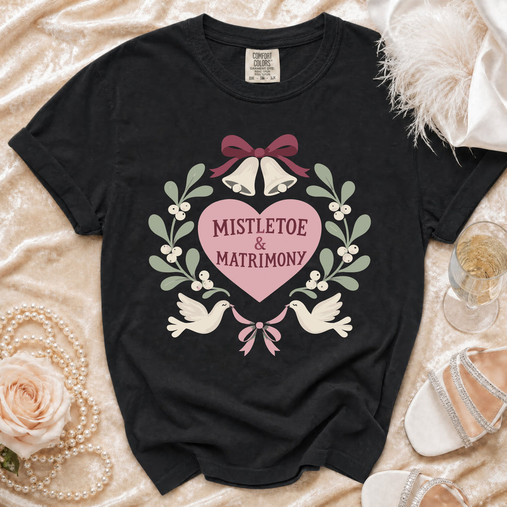 Black t-shirt with "Mistletoe & Matrimony" text and wedding-themed graphics.