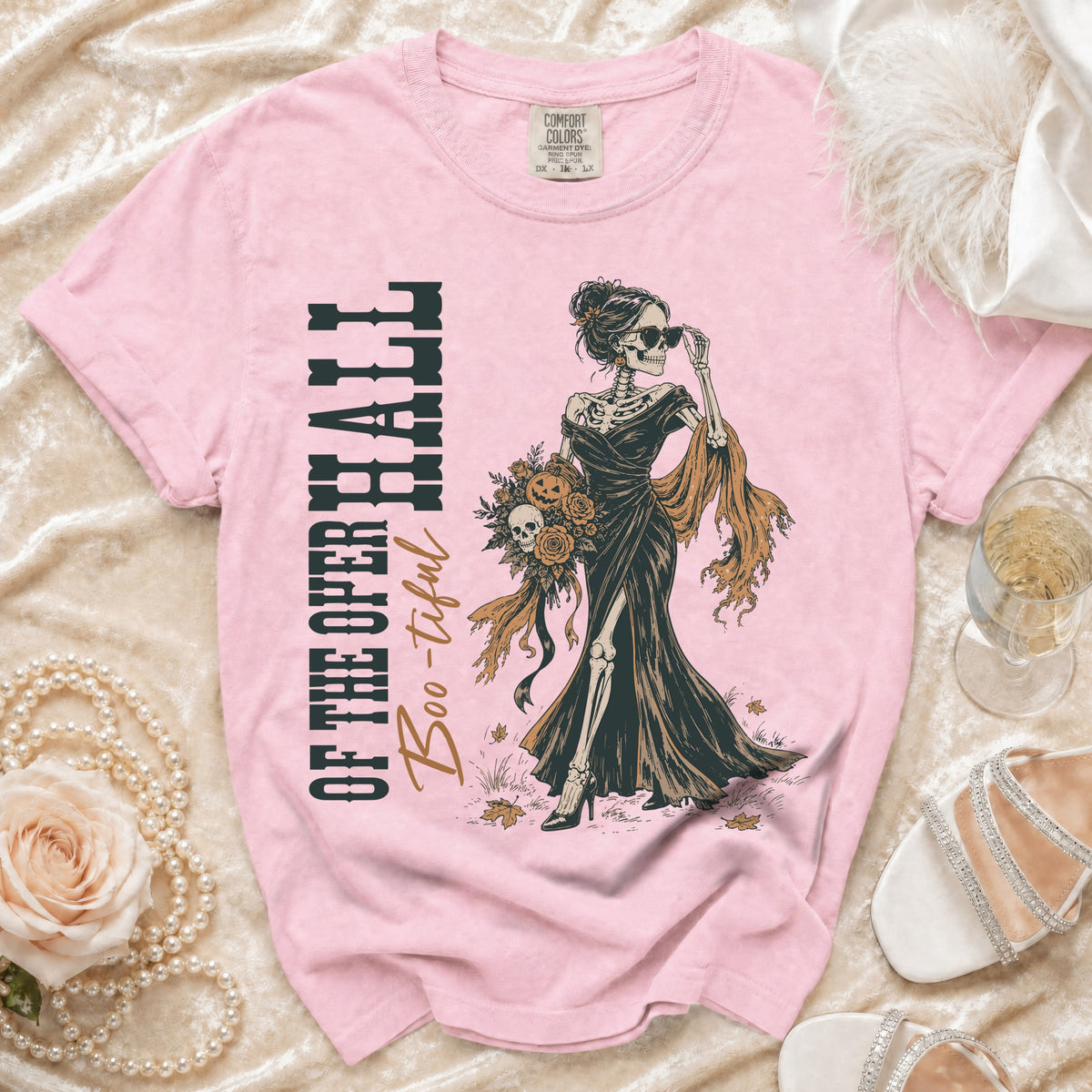 Pink t-shirt with skeleton woman graphic holding flowers and "OF THE OPERA HALL Boo-tiful" text.