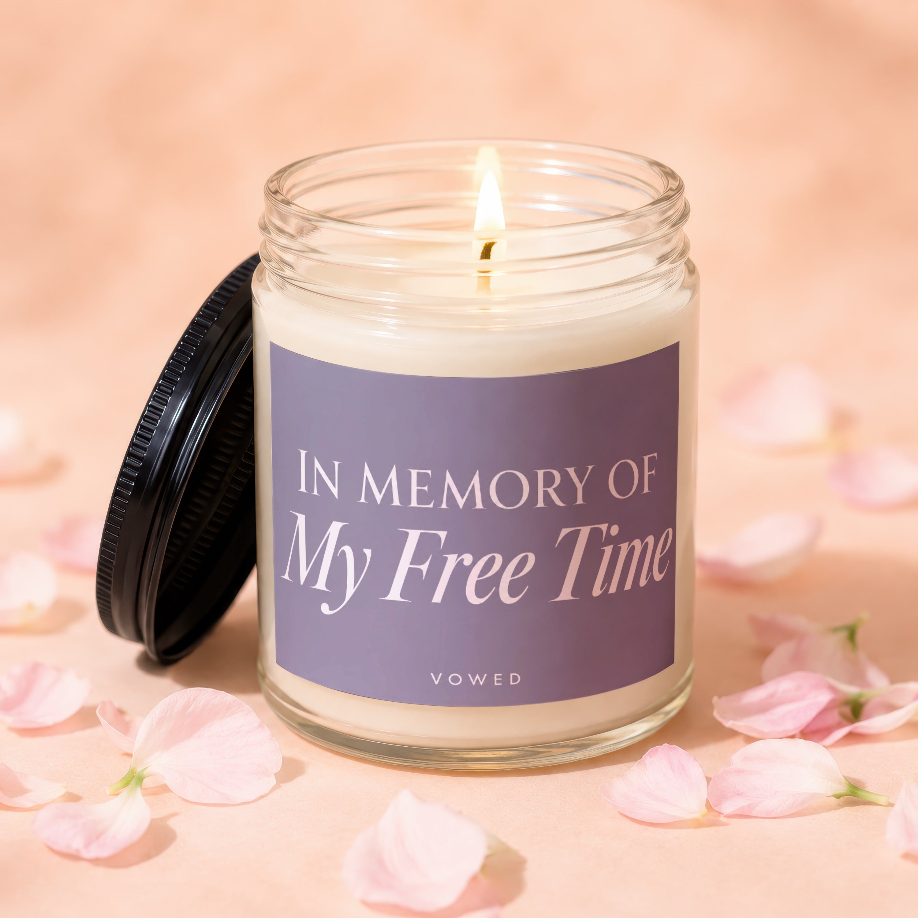 Candle with label reading "In Memory of My Free Time" surrounded by pink petals.