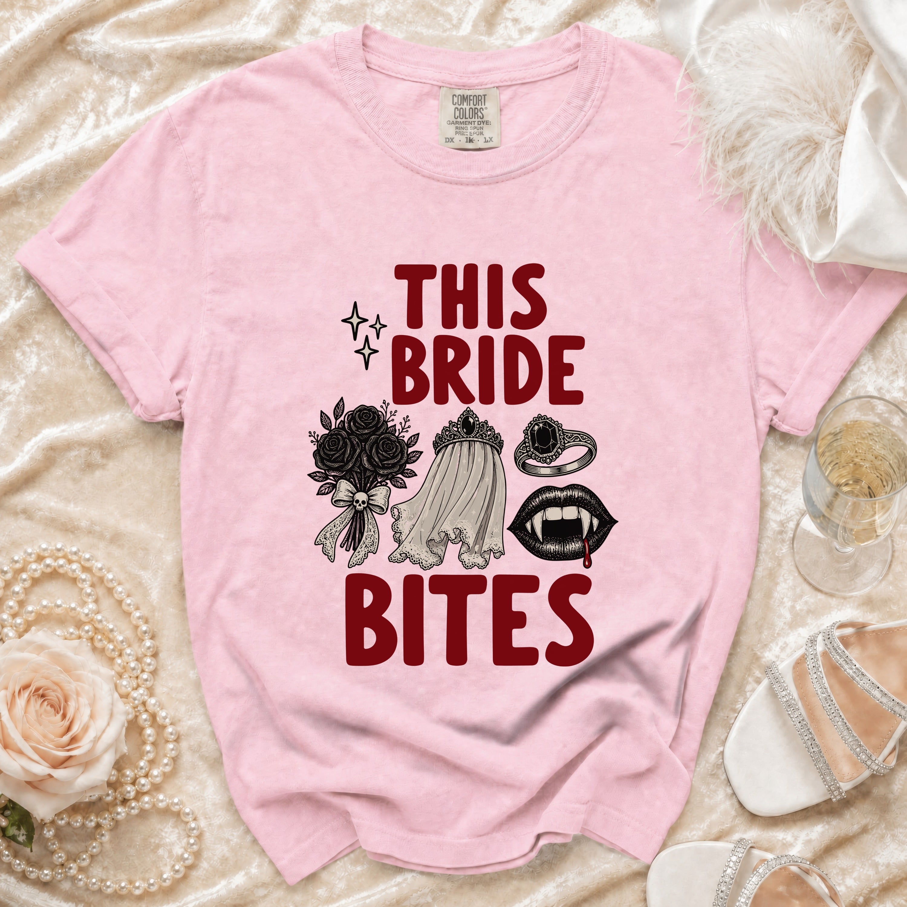 Pink t-shirt with "THIS BRIDE BITES" text and gothic bridal illustrations.