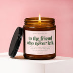 Amber candle with lit flame, pink label reads "to the friend who never left".