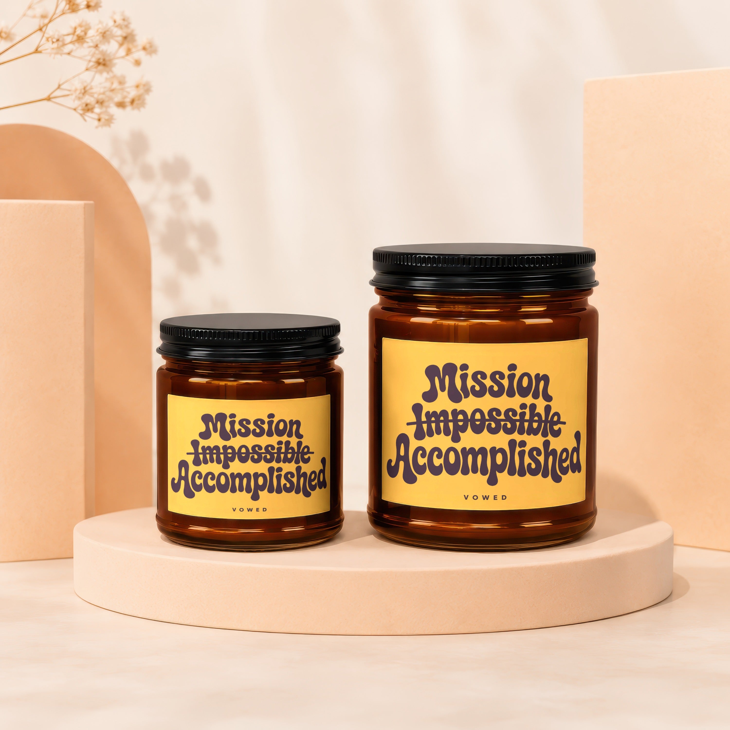 Two amber glass candles with yellow labels reading "Mission Impossible Accomplished" and "VOWED".