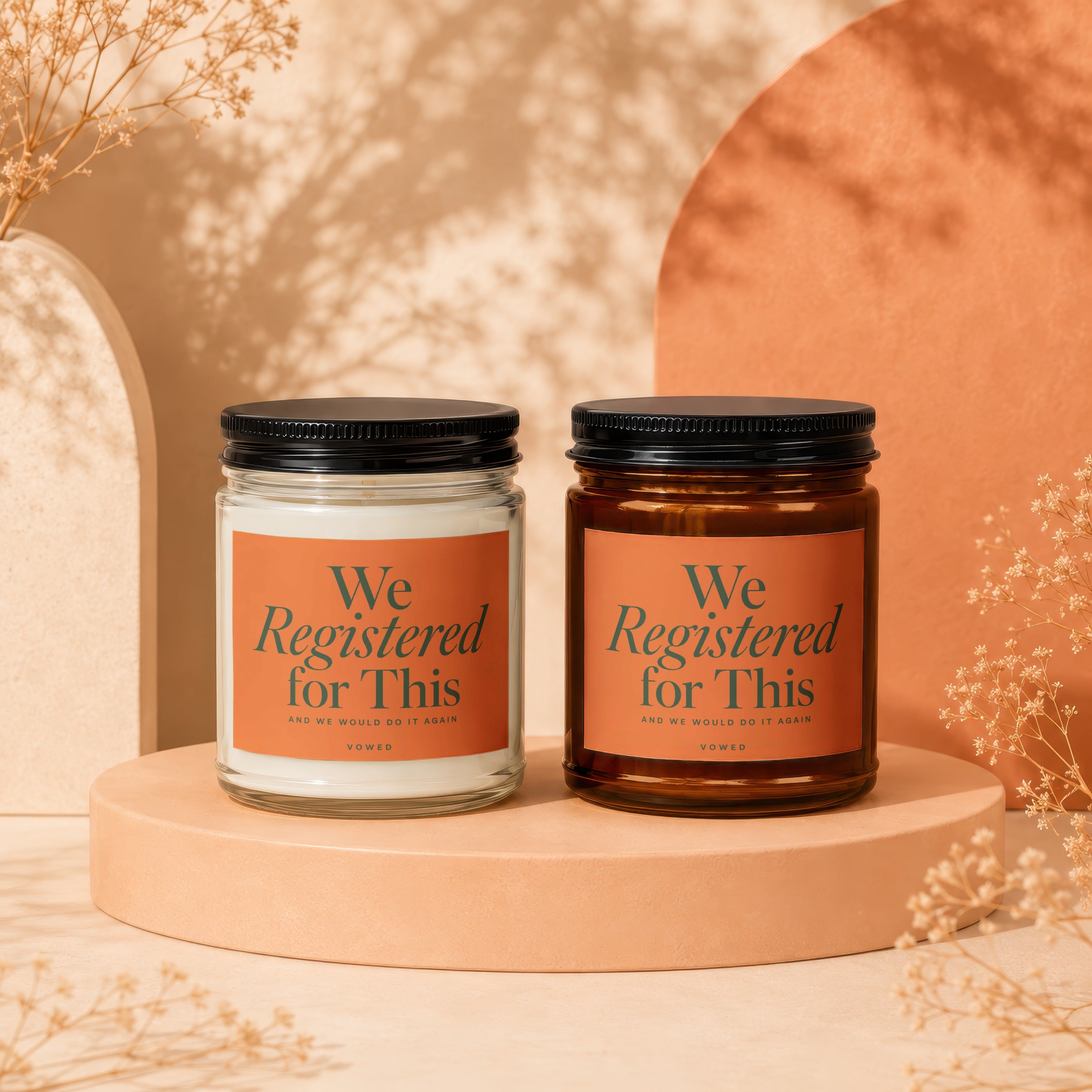 Two candles with "We Registered for This" text on orange labels.