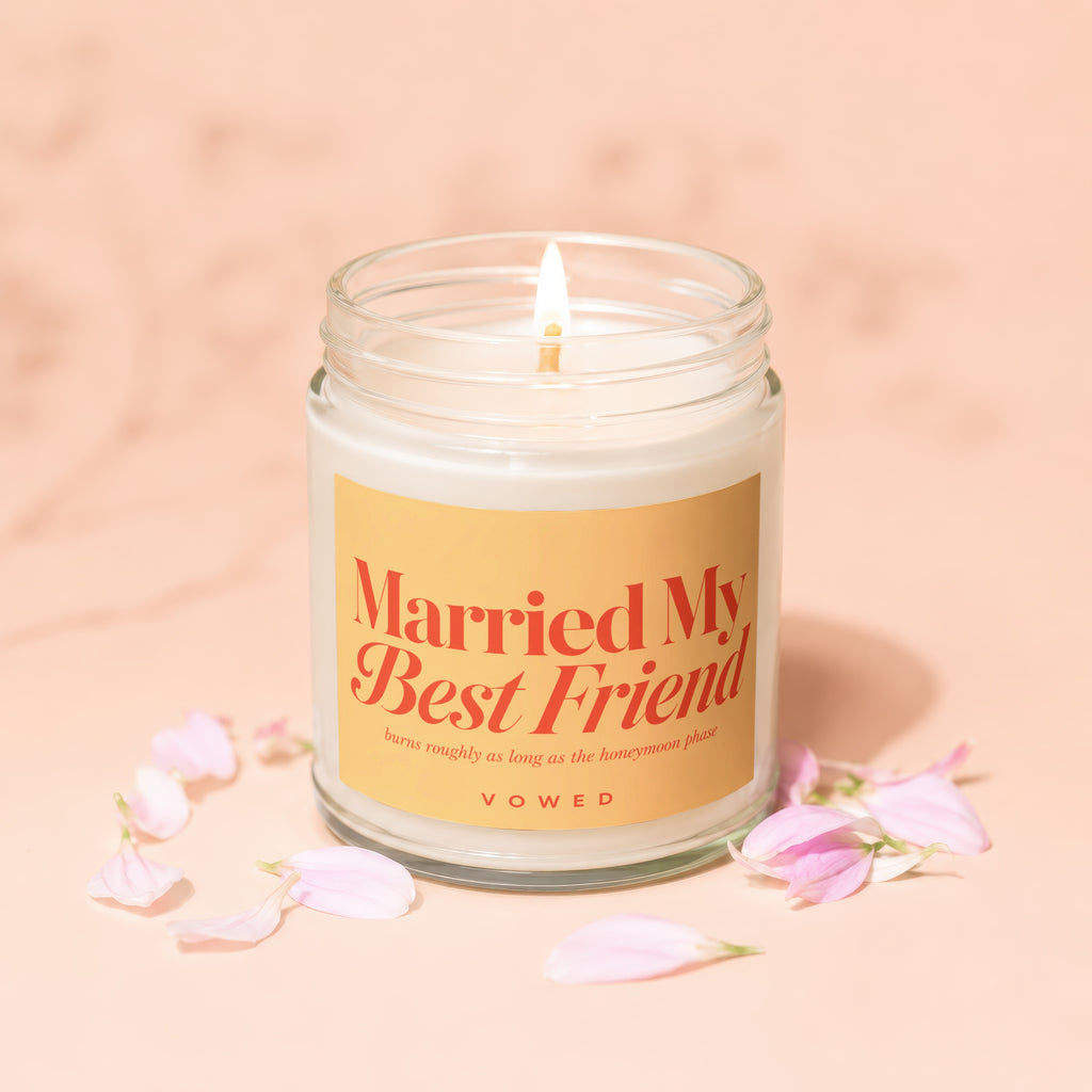 Candle with "Married My Best Friend" and "VOWED" text, surrounded by pink petals.