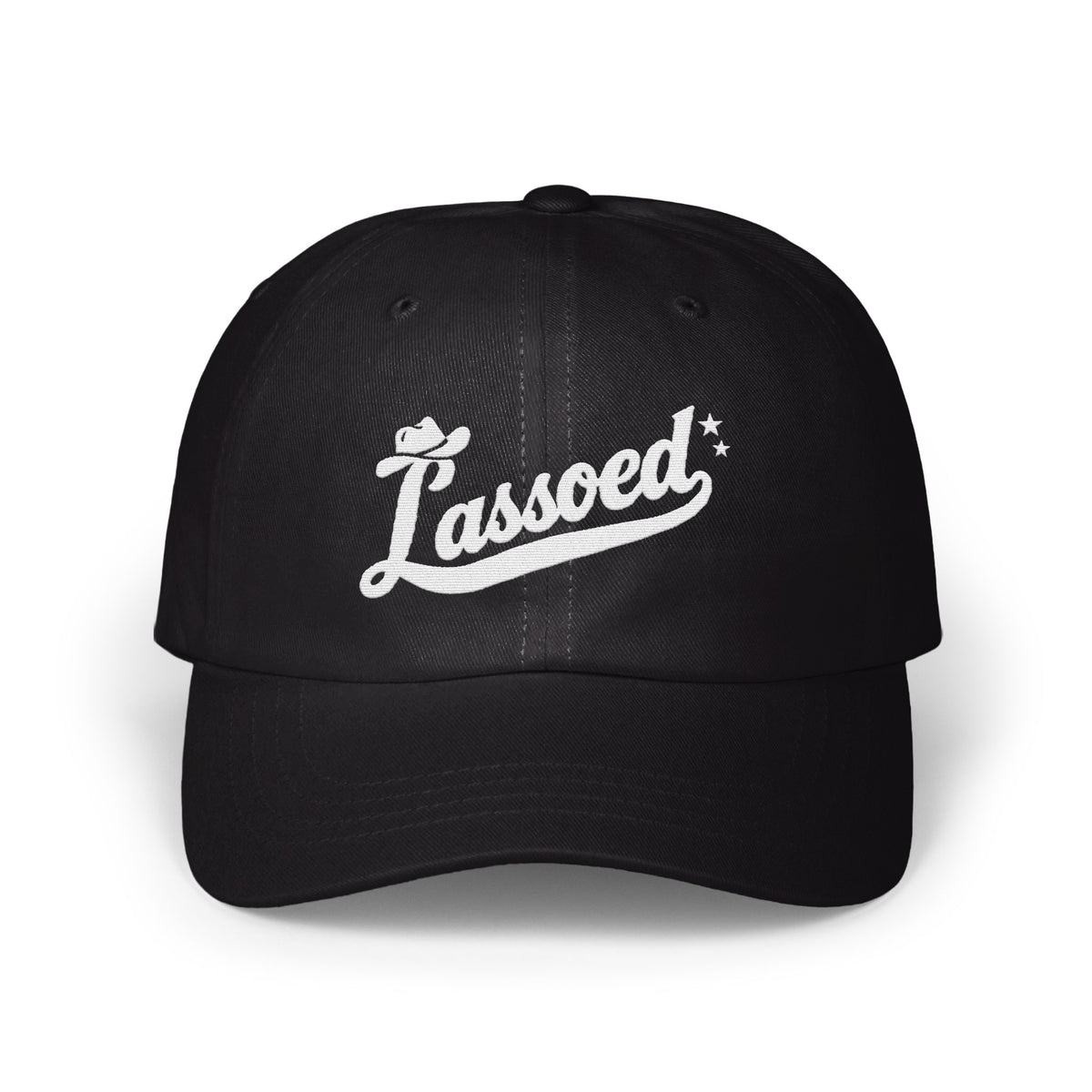 A black baseball cap with white embroidered cursive text that reads Lassoed on the front.