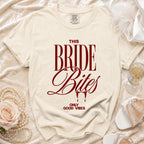 Cream t-shirt with "THIS BRIDE Bites ONLY GOOD VIBES" text in burgundy.