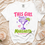 White t-shirt with pink text "THIS GIRL Needs a Margarita" and margarita graphic.