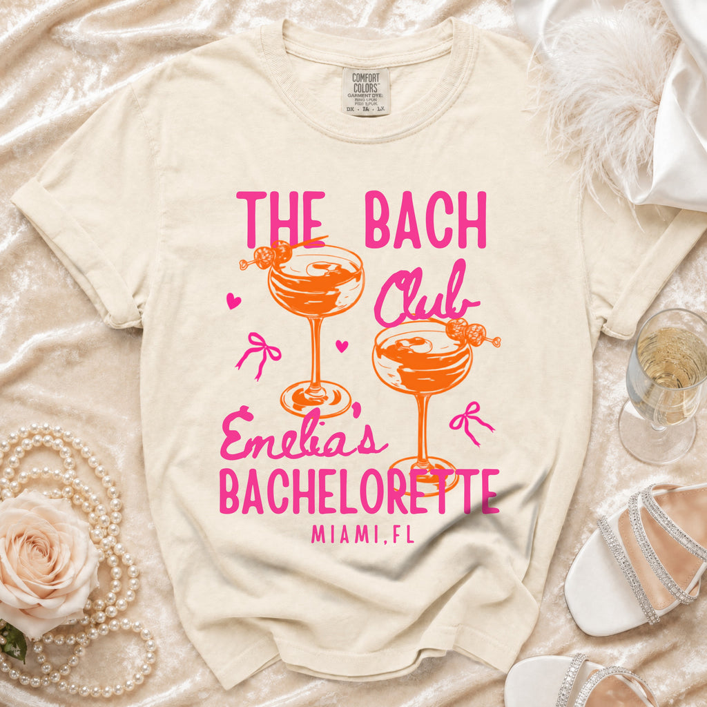 Cream t-shirt with "The Bach Club" and "Emelia's Bachelorette Miami, FL" text.