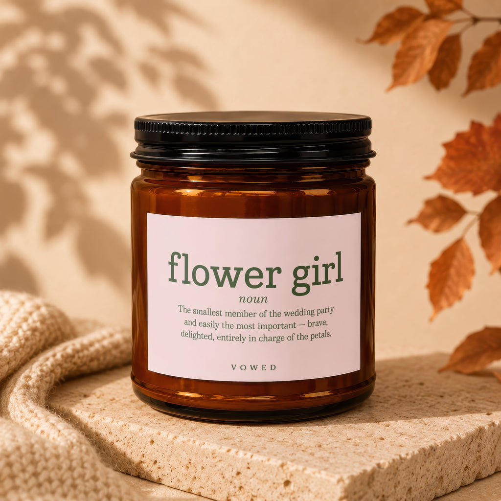 Brown glass candle labeled "flower girl noun" with descriptive text.