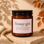 Brown glass candle labeled "flower girl noun" with descriptive text.