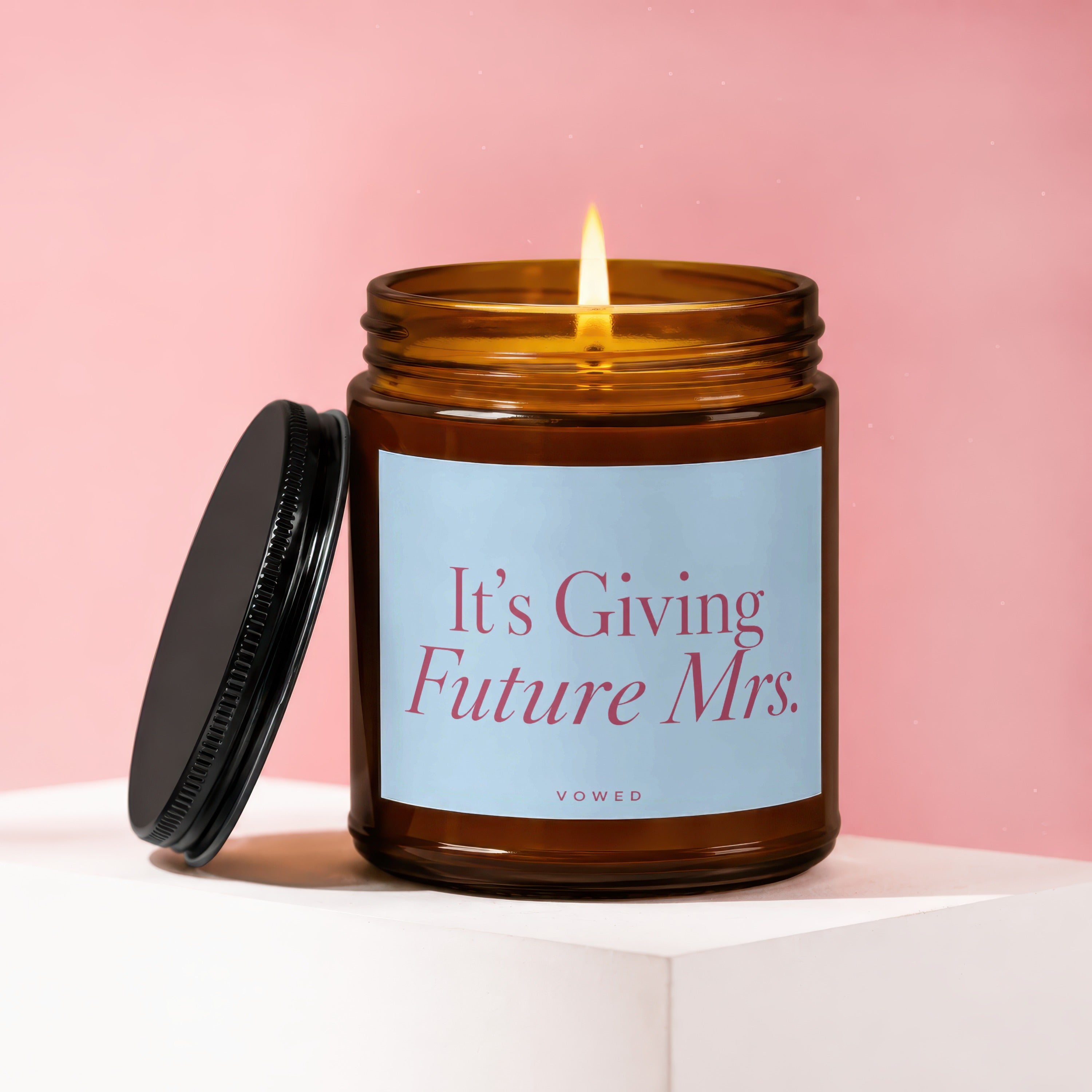 Amber candle with lit wick and text "It's Giving Future Mrs. VOWED".