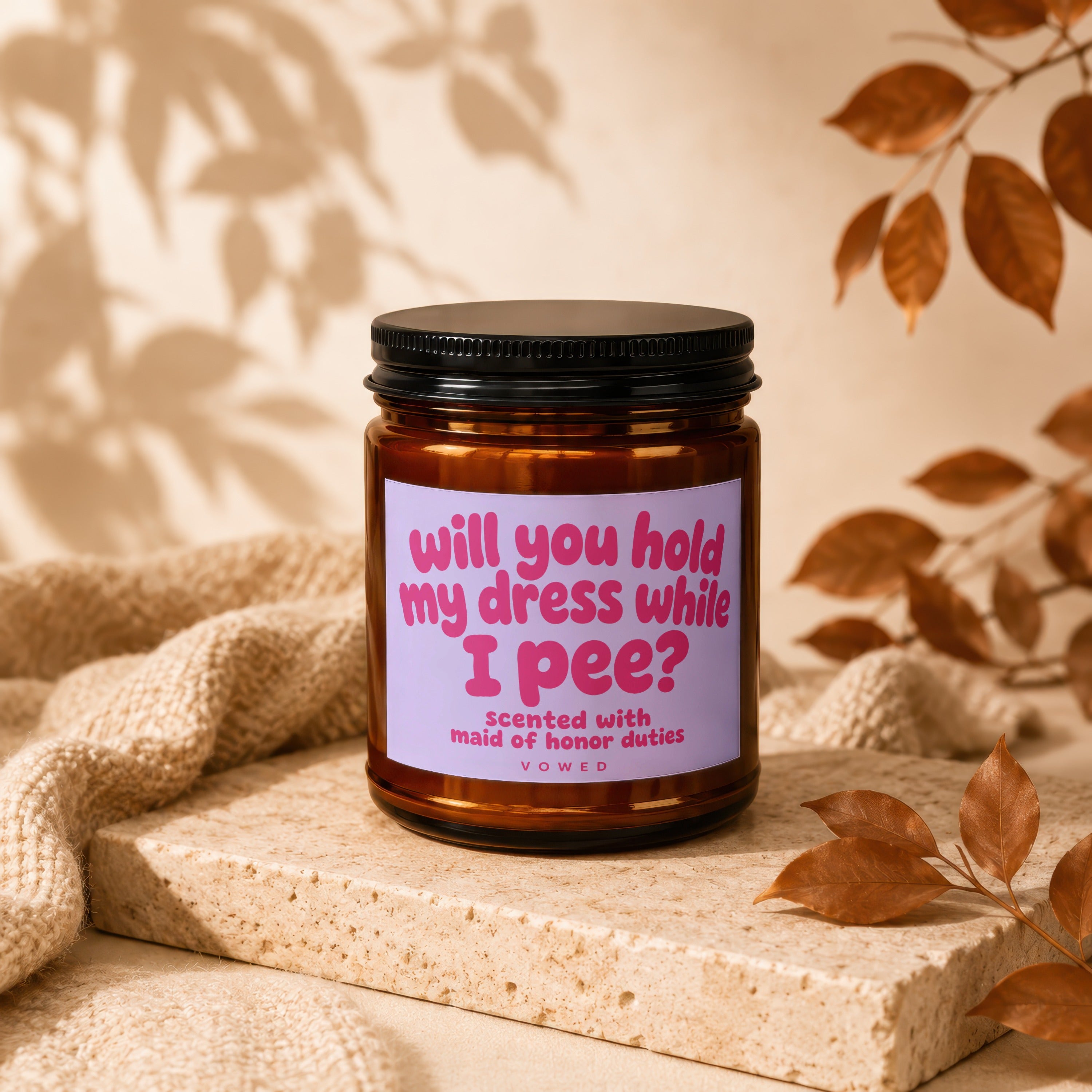 Amber candle with purple label reading "will you hold my dress while I pee?"