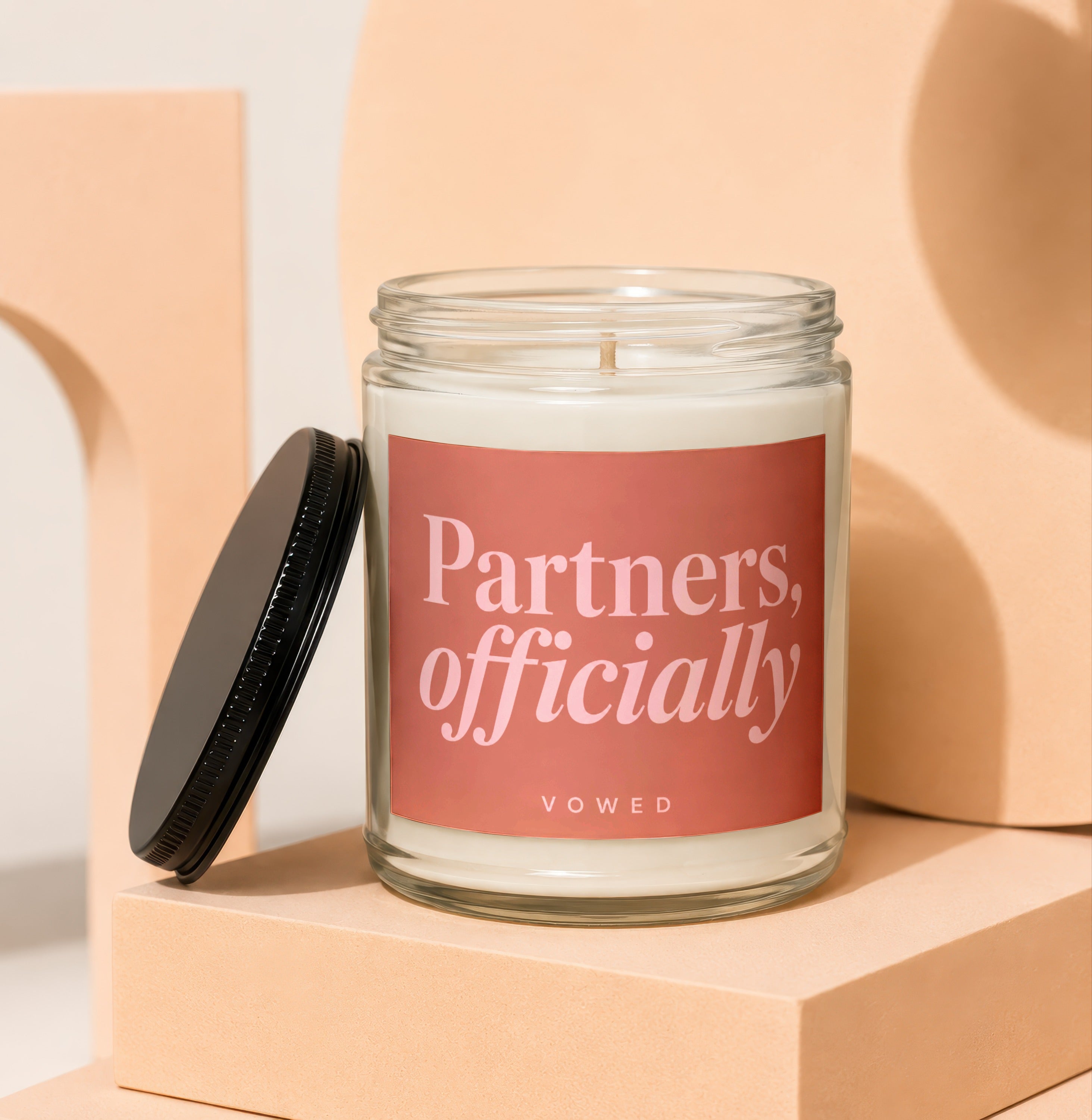 Candle with label reading "Partners, officially" and "VOWED".