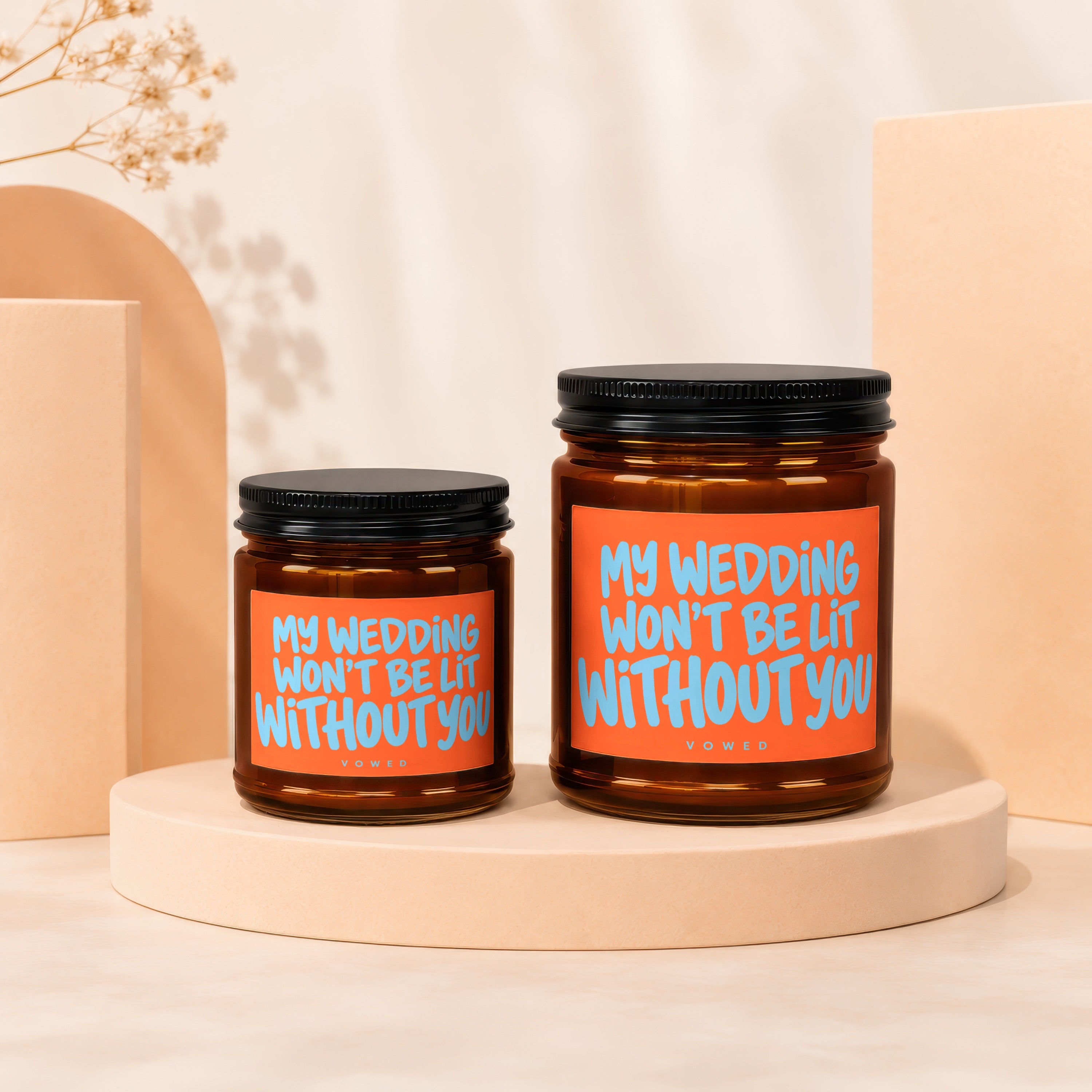 Two amber glass candles with orange labels reading "MY WEDDING WON'T BE LIT WITHOUT YOU".