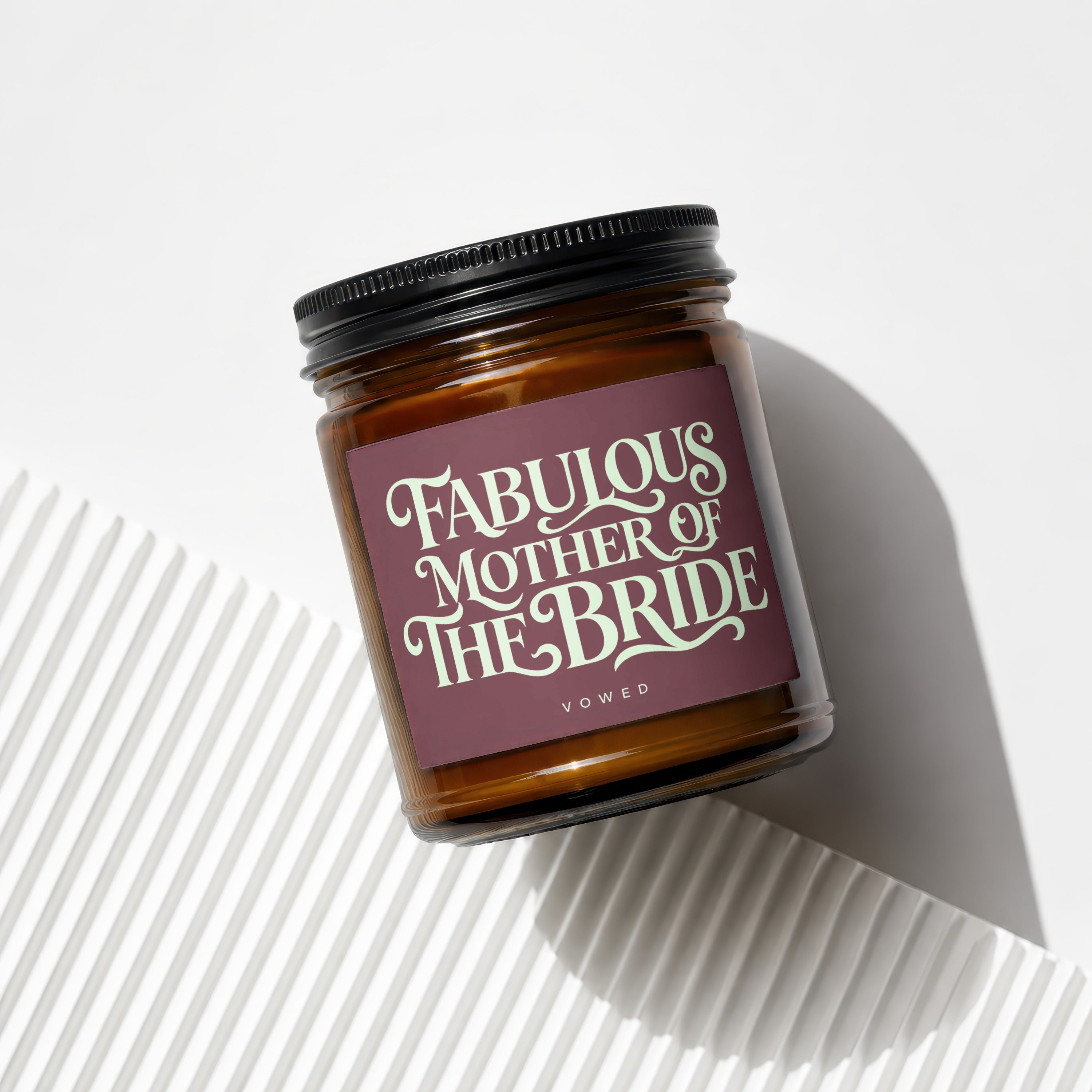 Brown candle in glass jar with "Fabulous Mother of The Bride" text on a plum label.
