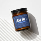 Amber jar candle with a blue label reading "SAY AYE, ALL IN FAVOR OF THE BRIDE."