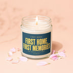 Jar candle with lit wick and dark blue label reading "First Home, First Memories."