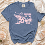 Blue t-shirt with "Mother of the Bride Era" graphic and champagne imagery.