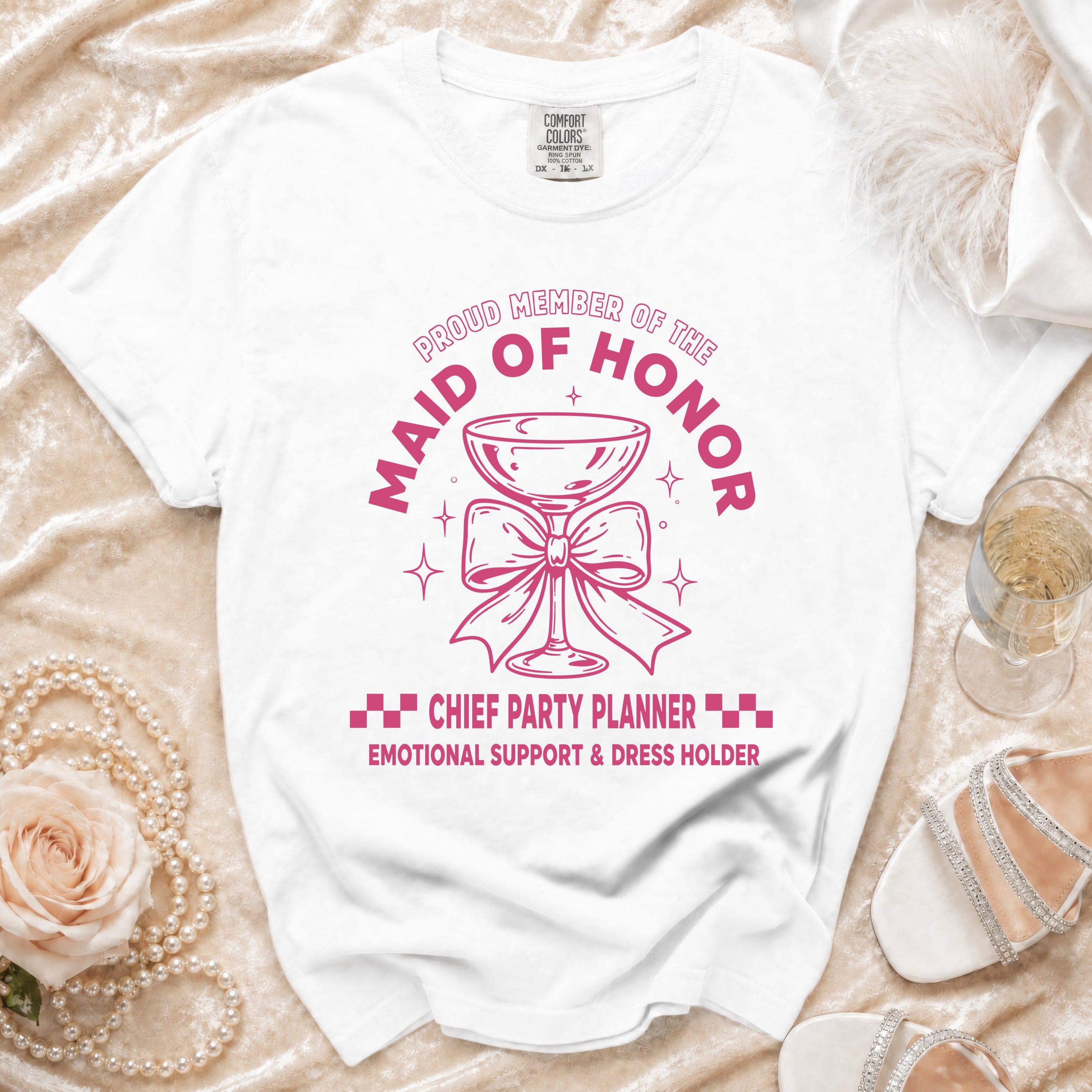 White t-shirt with pink text: "Proud Member of the Maid of Honor", "Chief Party Planner", "Emotional Support & Dress Holder".