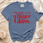 Blue t-shirt with red text reading "This Bride needs a Bigger Glass."