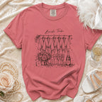 Pink t-shirt with "Bride Tribe" illustration of robes, flowers, and champagne.