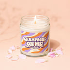 Lit candle in glass jar with "Champagne On Me! When You Say Yes!" text.