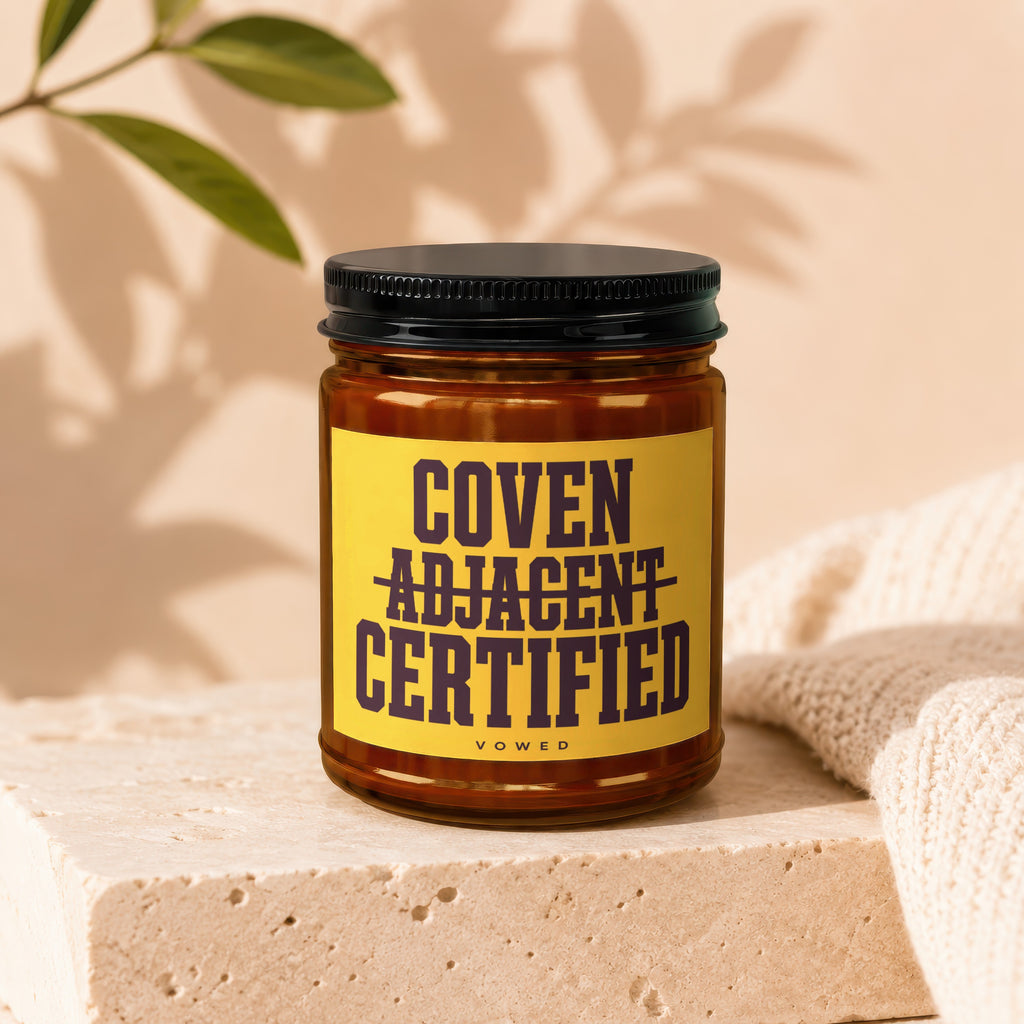 Amber glass jar with black lid, yellow label reads "Coven Adjacent Certified".