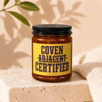 Amber glass jar with black lid, yellow label reads "Coven Adjacent Certified".