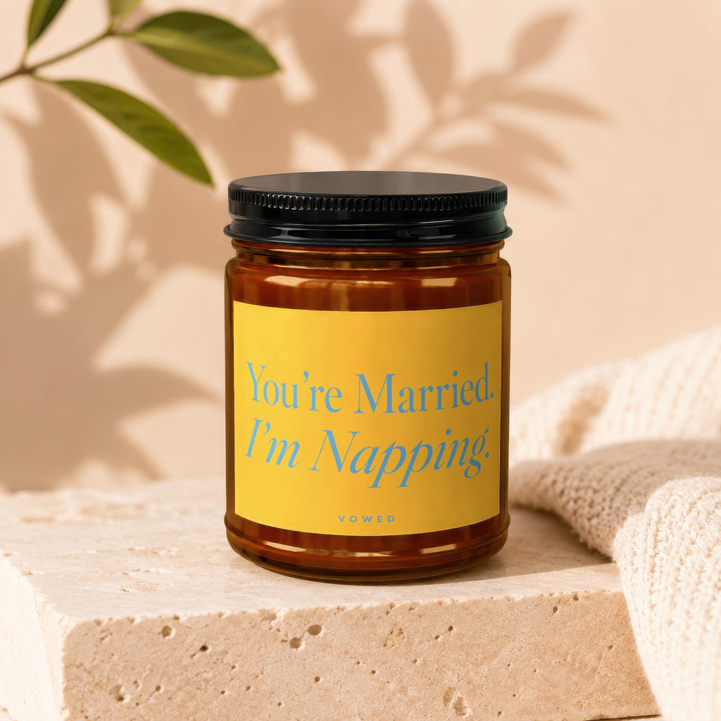Amber jar candle with black lid and yellow label reading "You're Married. I'm Napping."