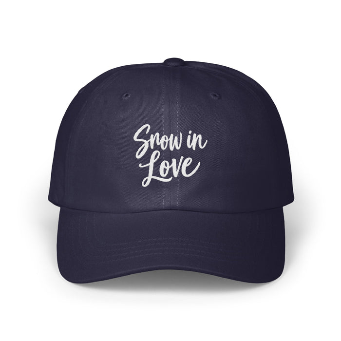 Dark blue baseball cap embroidered with the white script text "Snow in Love" on the front.