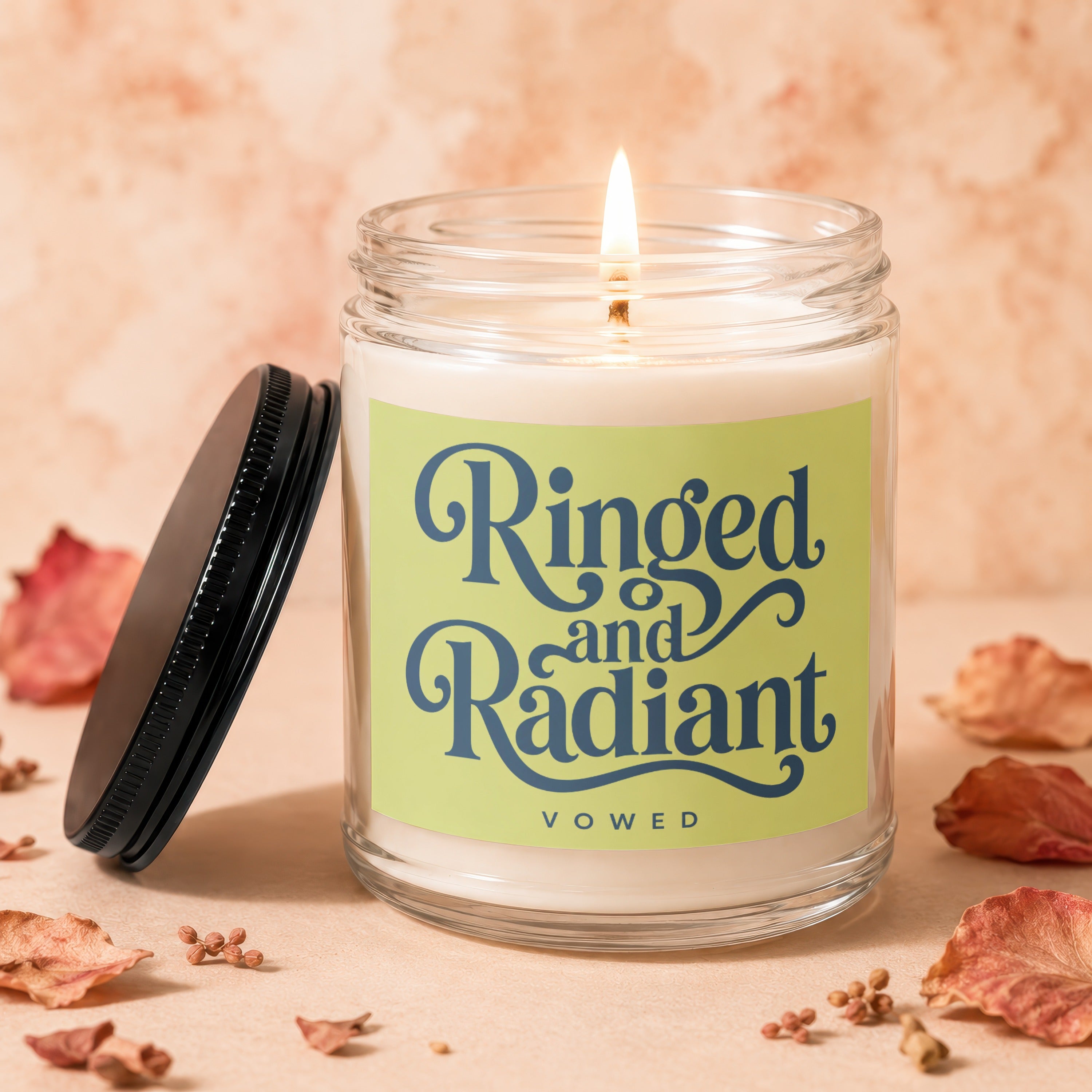 Lit candle in a glass jar with label "Ringed and Radiant VOWED".