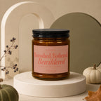 Brown candle with black lid, pink label saying "Betrothed, Bothered, Bewildered".
