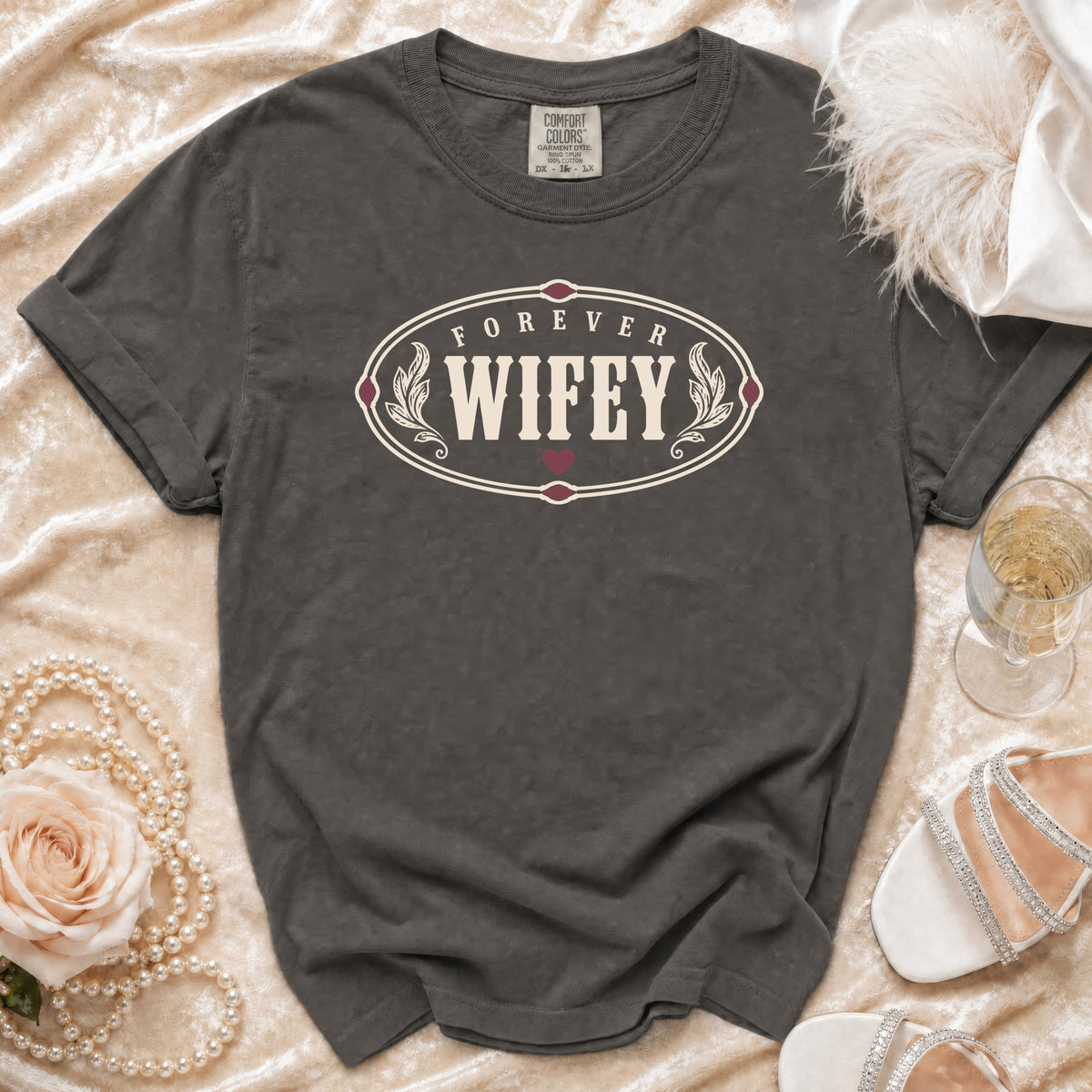 Dark grey t-shirt with "FOREVER WIFEY" oval graphic and decorative elements.