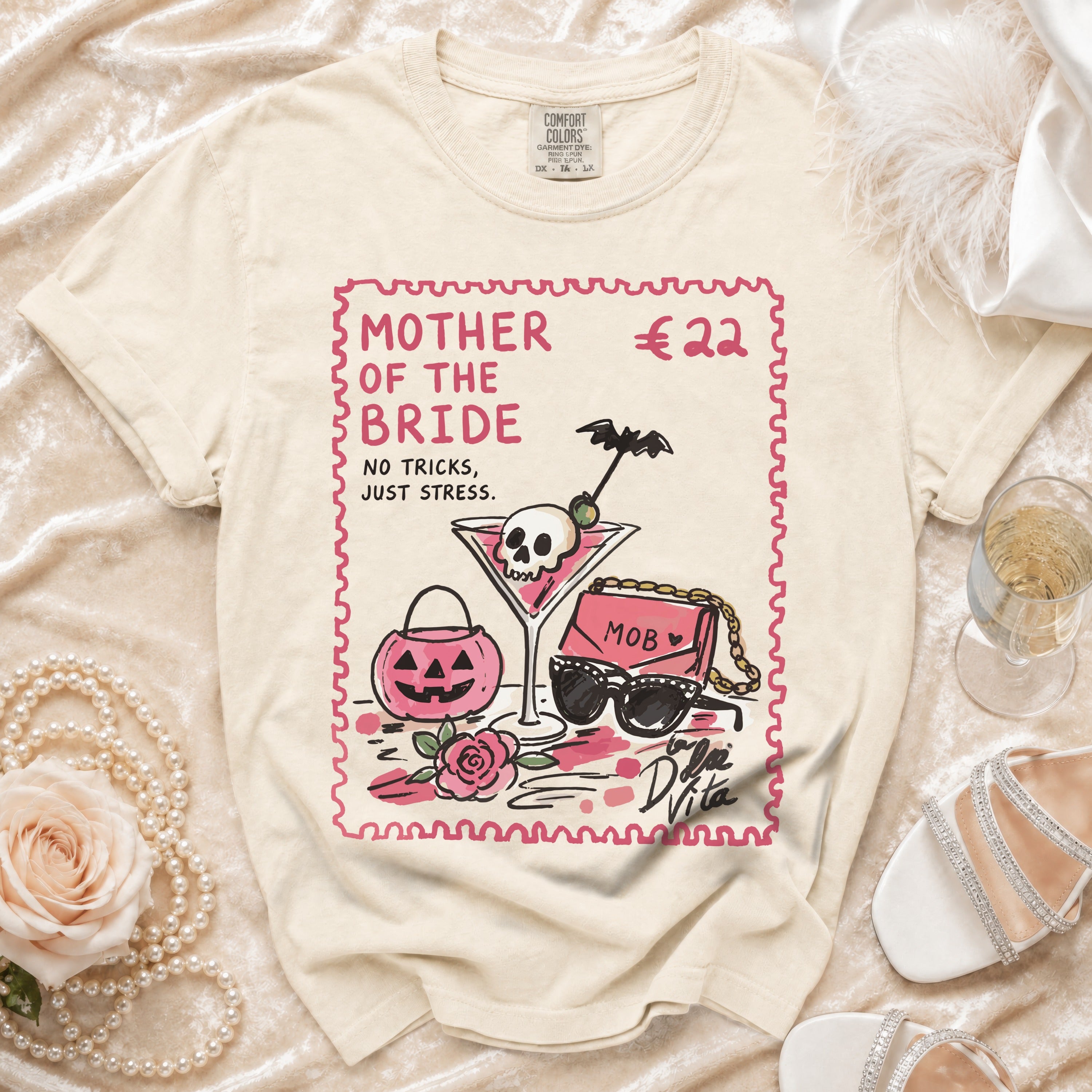Cream t-shirt with "MOTHER OF THE BRIDE" text and illustration of martini, purse, and sunglasses.