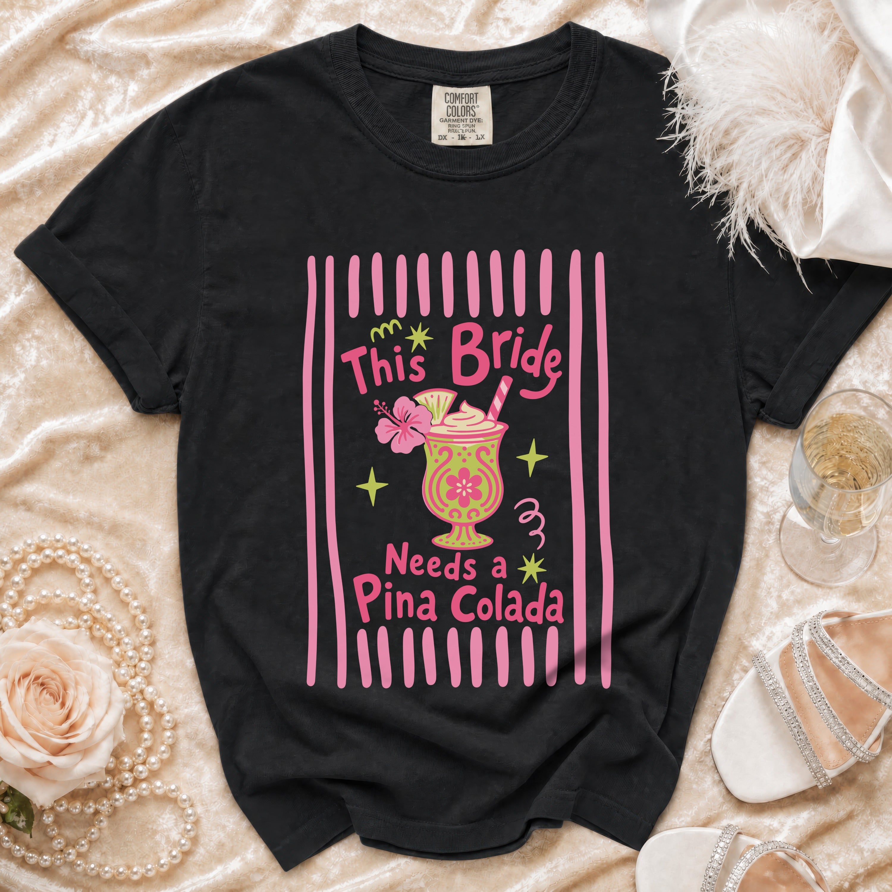 Black t-shirt with "This Bride Needs a Piña Colada" graphic and cocktail.