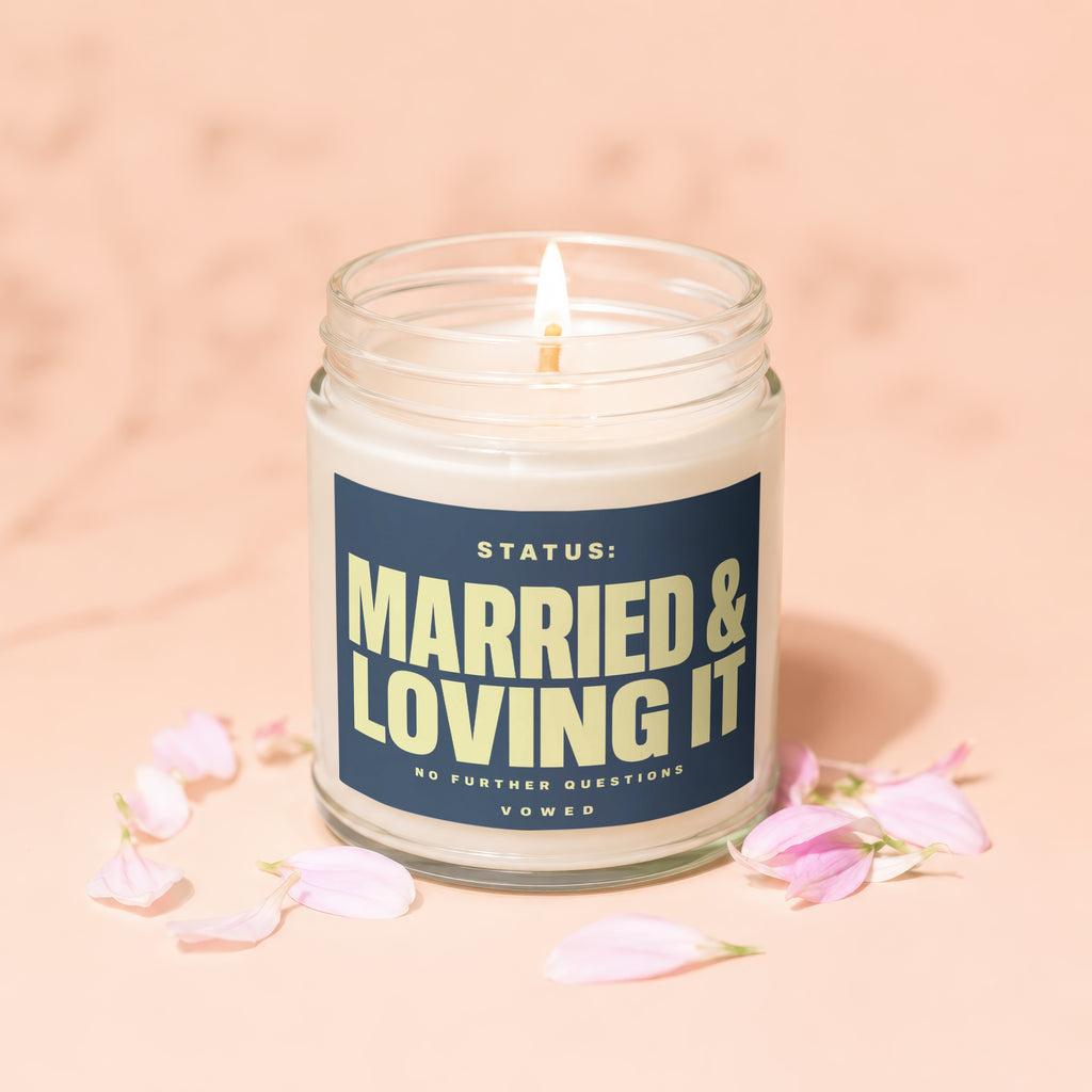 Lit candle in glass jar with text "STATUS: MARRIED & LOVING IT".