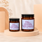 Two amber glass candles with black lids, each labeled "The grooms have entered."