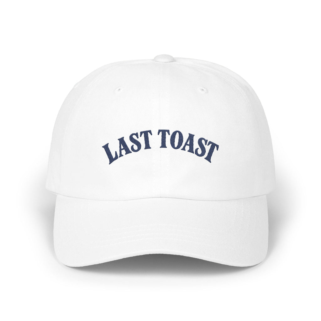 White baseball cap with embroidered "LAST TOAST" text in navy blue.