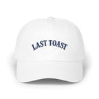White baseball cap with embroidered "LAST TOAST" text in navy blue.