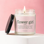 Lit candle in jar labeled "flower girl noun" with wedding party description.
